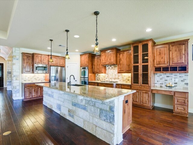 kitchen with stainless steel appliances, backsplash, an island with sink, and dark hardwood / wood-style floors