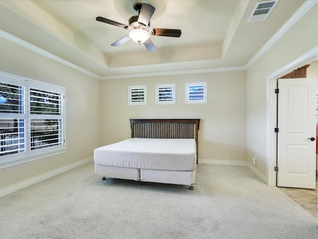 carpeted bedroom featuring ceiling fan, ornamental molding, and a tray ceiling