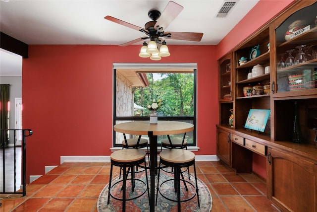 dining space featuring visible vents, built in study area, ceiling fan, baseboards, and tile patterned floors