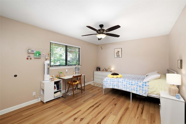 bedroom with ceiling fan, light wood-style flooring, and baseboards