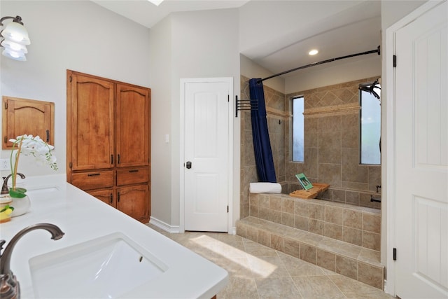 bathroom with recessed lighting, a sink, a tile shower, and tile patterned floors