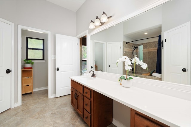 full bath with baseboards, a tile shower, and vanity