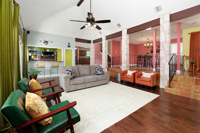 living area with visible vents, vaulted ceiling, wood finished floors, and decorative columns