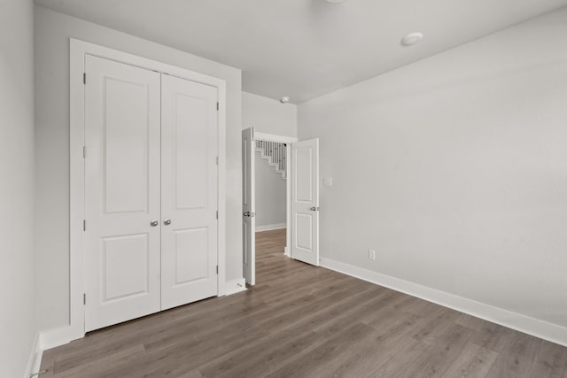 unfurnished bedroom featuring hardwood / wood-style floors and a closet