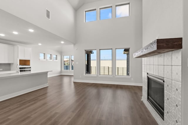 unfurnished living room featuring dark hardwood / wood-style floors and high vaulted ceiling