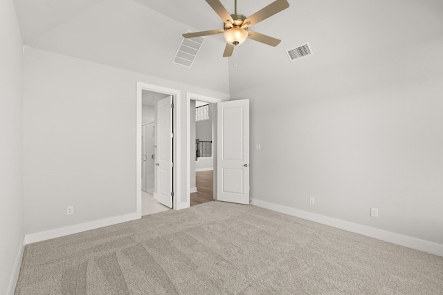 unfurnished bedroom with ensuite bath, ceiling fan, light carpet, and vaulted ceiling