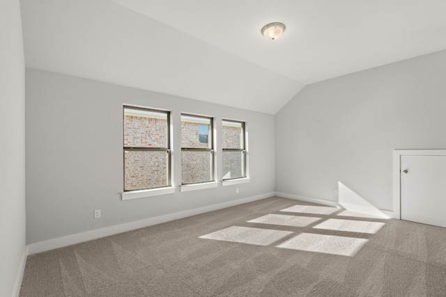 carpeted spare room featuring lofted ceiling