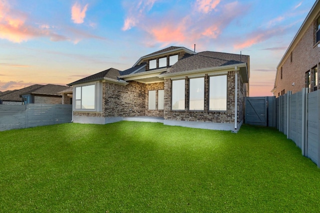 back house at dusk with a yard