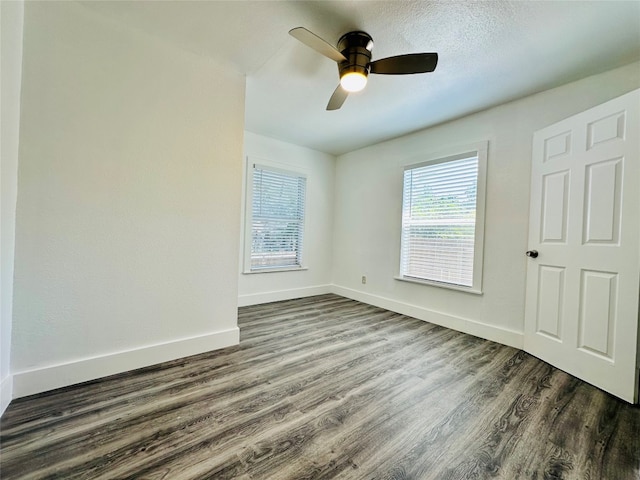 spare room with dark wood-type flooring and ceiling fan