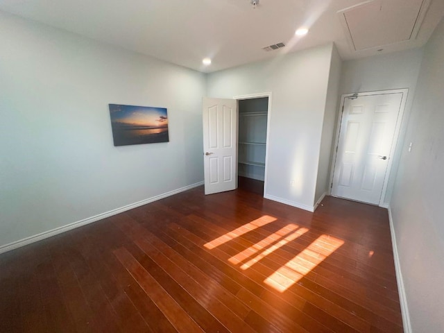 unfurnished bedroom featuring a closet and dark wood-type flooring