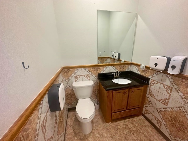 bathroom featuring tile walls, tile floors, vanity, and toilet