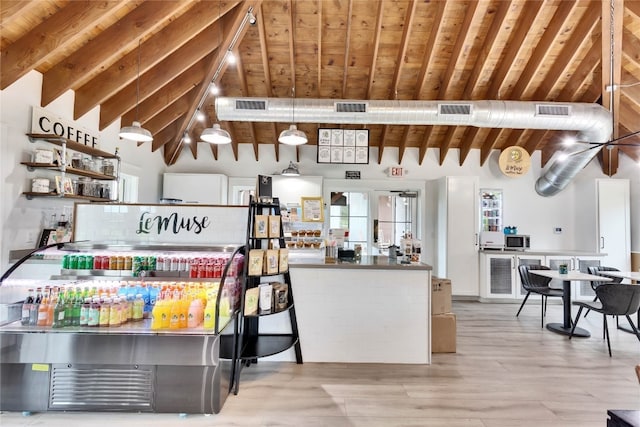 kitchen with vaulted ceiling with beams, pendant lighting, wood ceiling, and light hardwood / wood-style flooring