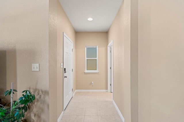 hall with light tile patterned floors