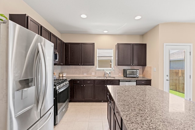 212 Timber Brook Dr, Hutto, TX 78634 - kitchen with a sink, appliances with stainless steel finishes, dark brown cabinetry, and tasteful backsplash