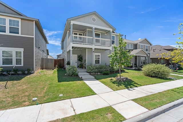 view of front facade with a balcony and a front lawn