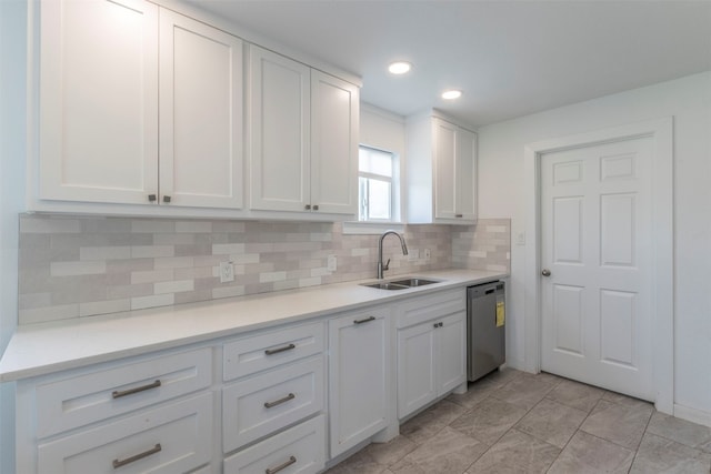 kitchen with dishwasher, white cabinetry, backsplash, and sink