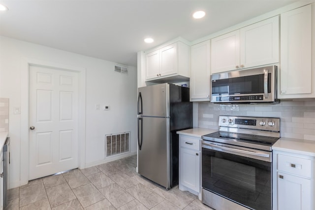 kitchen featuring stainless steel appliances, white cabinets, and tasteful backsplash