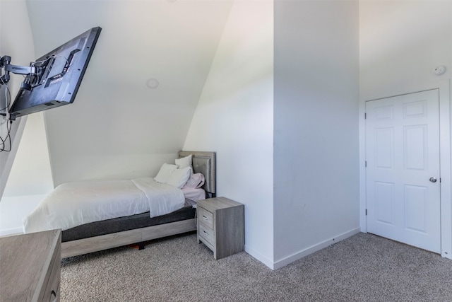 bedroom featuring light colored carpet and vaulted ceiling