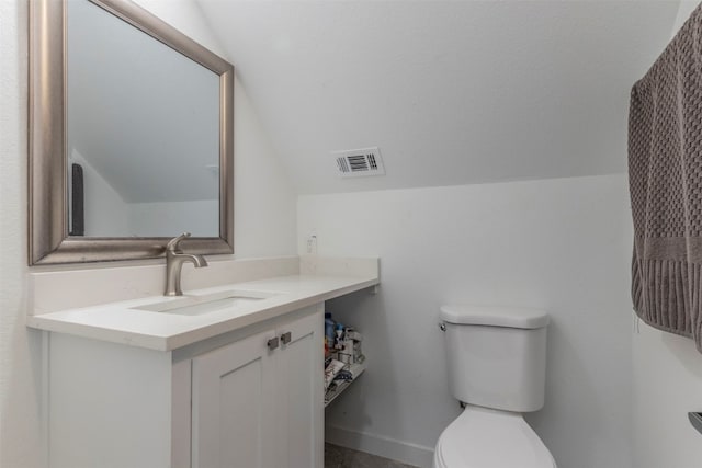 bathroom featuring vanity, vaulted ceiling, and toilet