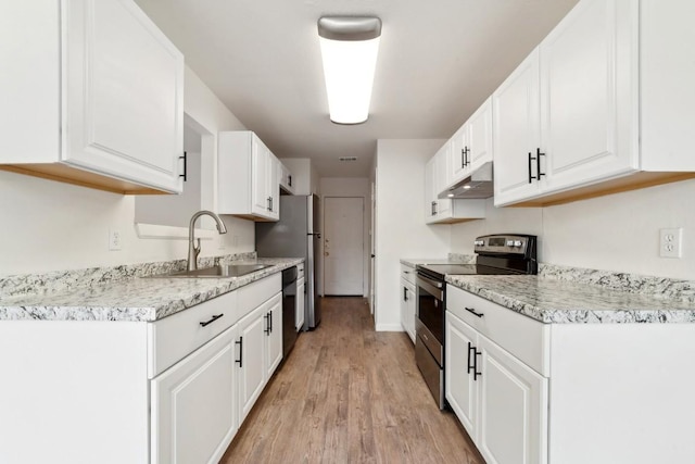 kitchen featuring light stone countertops, white cabinetry, sink, light hardwood / wood-style flooring, and black appliances