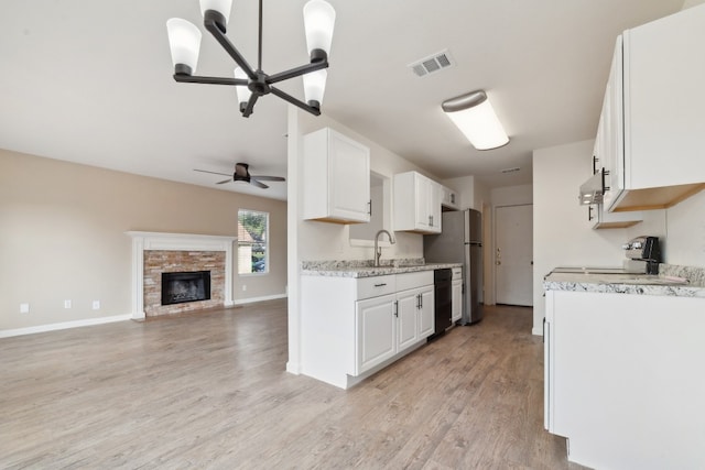 kitchen featuring ceiling fan with notable chandelier, light wood-type flooring, white cabinetry, and range