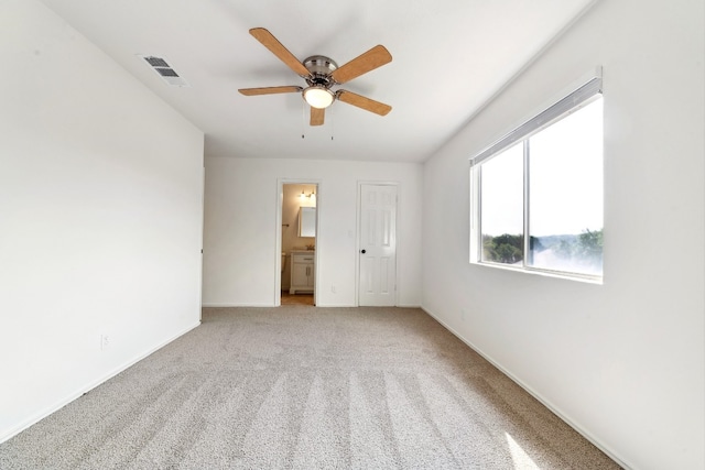 unfurnished bedroom with carpet flooring, a closet, ensuite bathroom, and ceiling fan