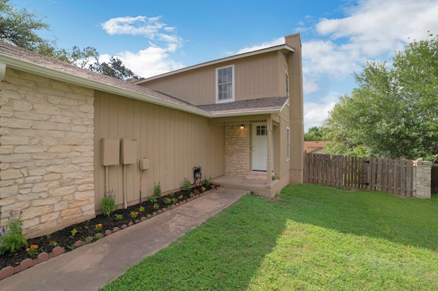 entrance to property with a lawn