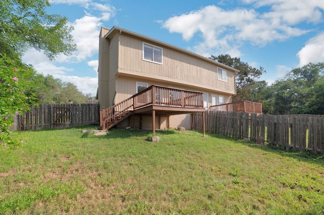 rear view of house with a yard and a wooden deck