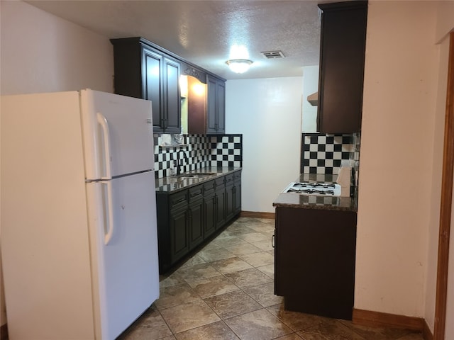 kitchen with white fridge, tasteful backsplash, and light tile floors