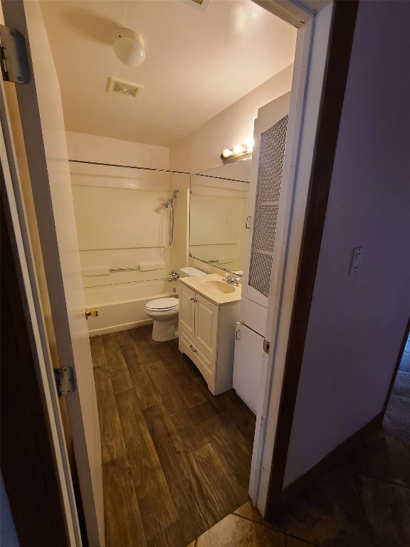 full bathroom featuring tub / shower combination, wood-type flooring, vanity, and toilet