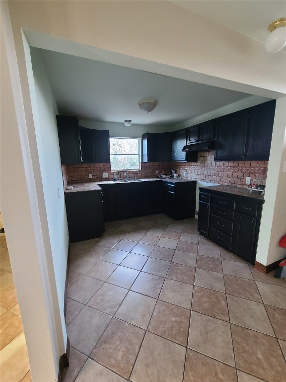 kitchen with sink, backsplash, and light tile floors