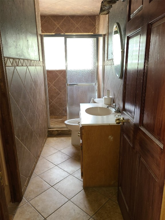 bathroom with tile flooring, tile walls, a shower with door, vanity, and toilet