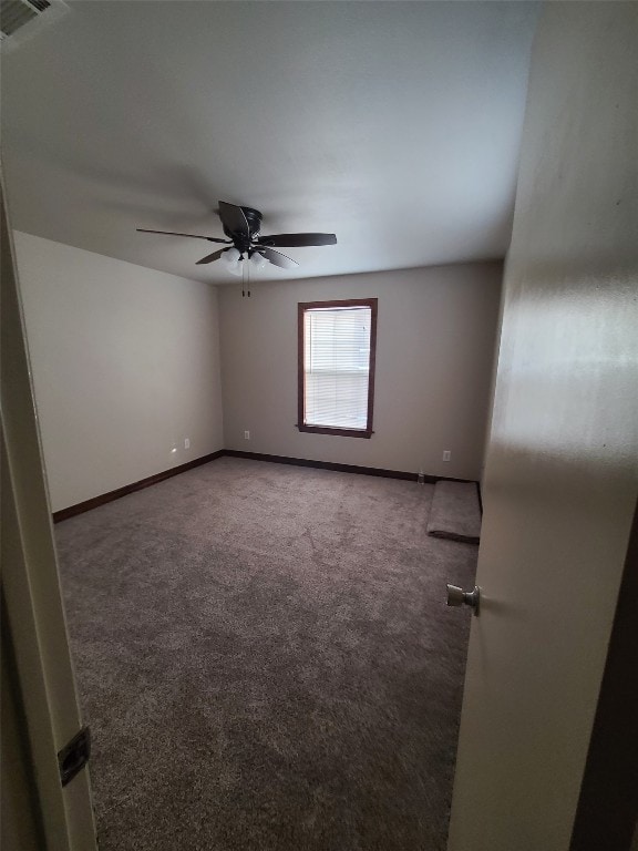 carpeted spare room featuring ceiling fan