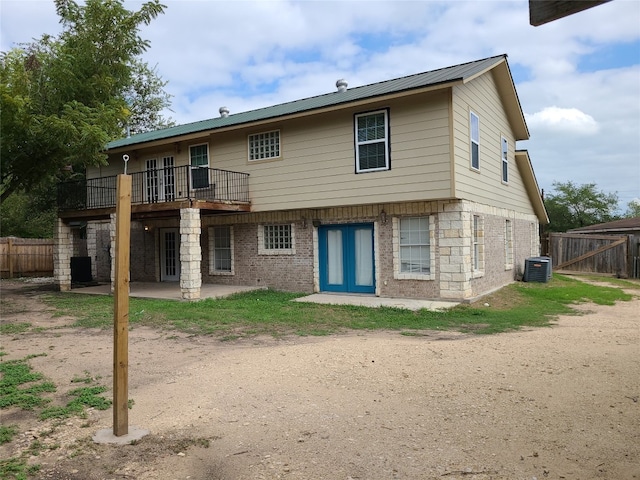 back of property with a balcony and central air condition unit