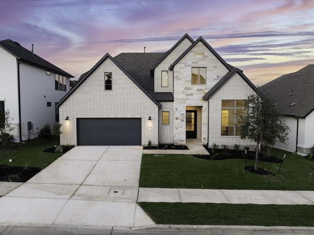 french provincial home featuring a lawn and a garage