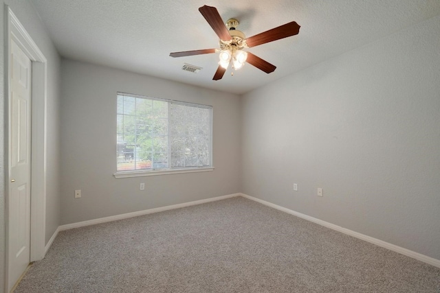 unfurnished room with ceiling fan, carpet floors, and a textured ceiling