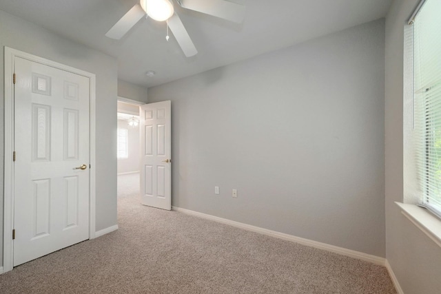 unfurnished bedroom featuring ceiling fan and carpet