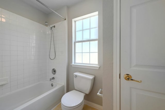 bathroom featuring tiled shower / bath combo and toilet