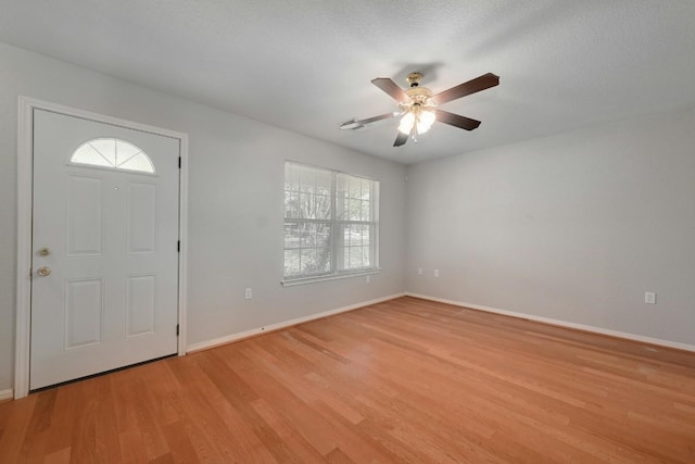 foyer with a textured ceiling, light hardwood / wood-style flooring, and ceiling fan