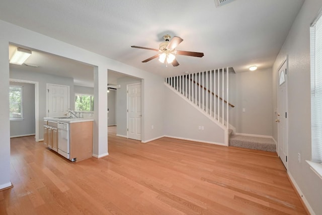 kitchen featuring dishwasher, light hardwood / wood-style floors, ceiling fan, and sink