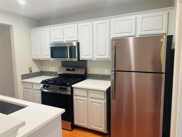 kitchen featuring white cabinets, stainless steel appliances, light hardwood / wood-style floors, and sink