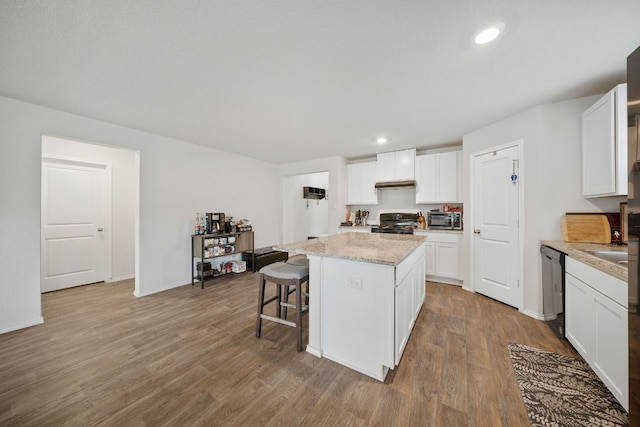 kitchen featuring white cabinets, appliances with stainless steel finishes, light wood-type flooring, and a kitchen island