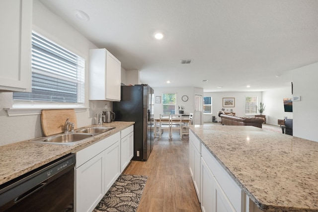 kitchen featuring white cabinets, light wood-type flooring, sink, and black appliances