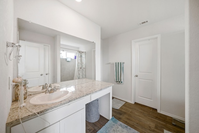 bathroom with a shower with shower curtain, wood-type flooring, and vanity