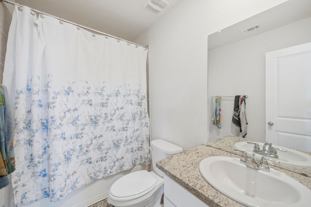 full bathroom with vanity, shower / tub combo, and toilet