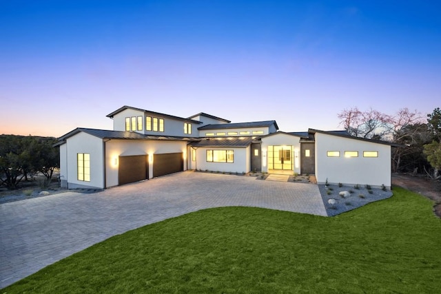 view of front of home featuring a garage and a lawn