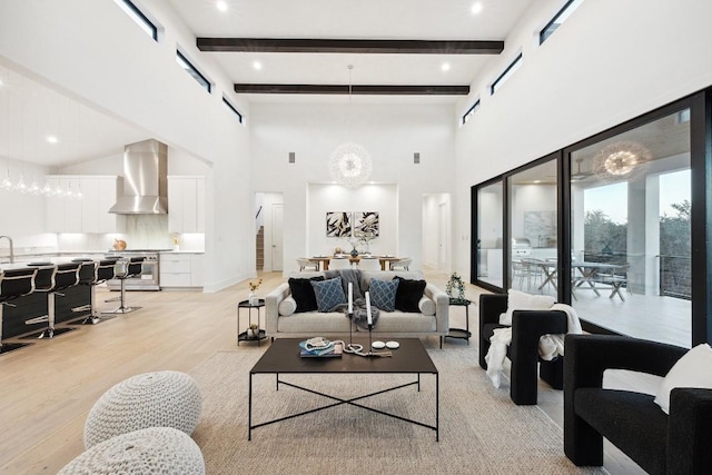 living room featuring beamed ceiling, light wood-type flooring, and a high ceiling