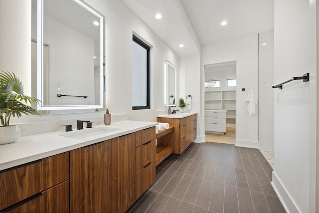 18116 Cedar Sage Ct, Lago Vista, TX 78645 - bathroom featuring two vanities, recessed lighting, tile patterned floors, a spacious closet, and baseboards