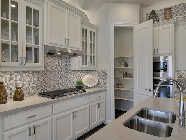 kitchen featuring sink, backsplash, white cabinetry, and appliances with stainless steel finishes