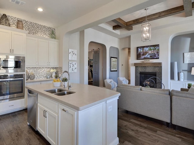 20517 Martin Ln, Pflugerville, TX 78660 - kitchen featuring stainless steel appliances, a sink, arched walkways, coffered ceiling, and open floor plan